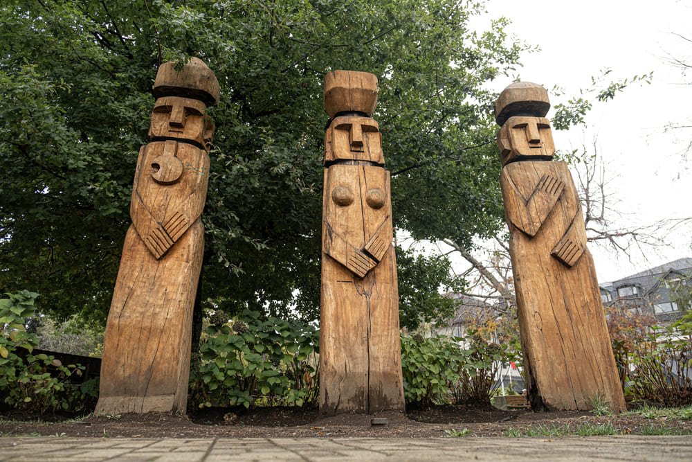 Totems de madera delante árboles